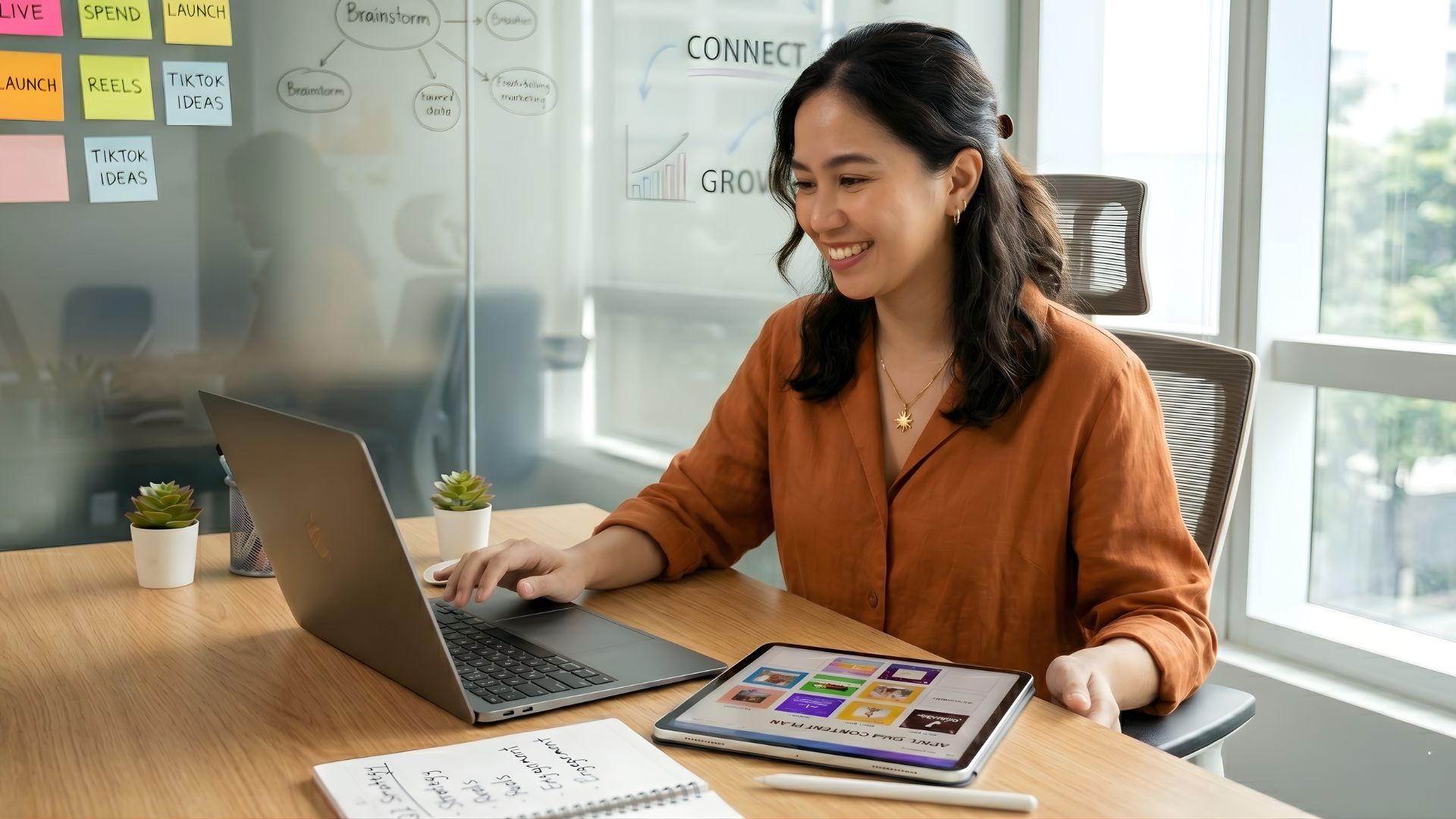 offshore social media manager working with a laptop and ipad in a office