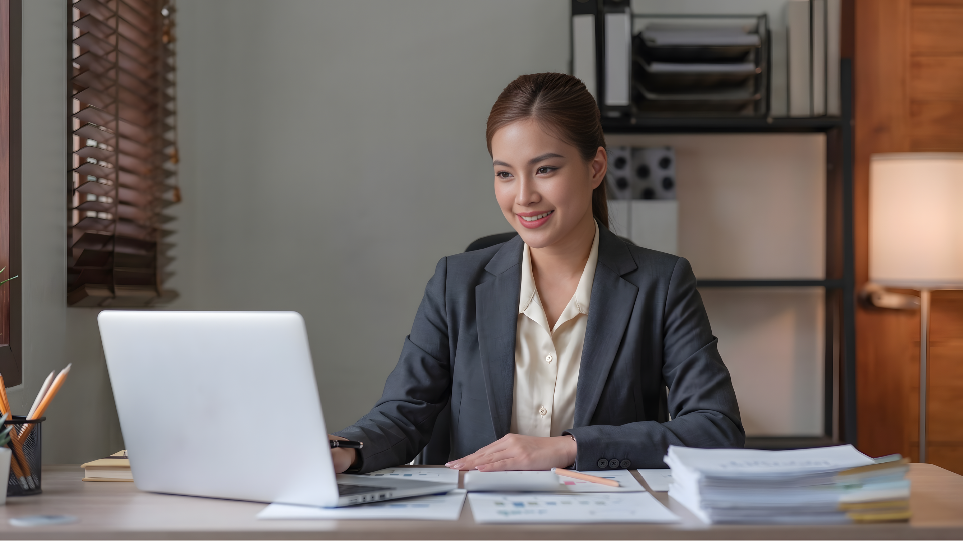 filipina remote financial planning and analysis analyst working with a laptop and pile of documents on the table