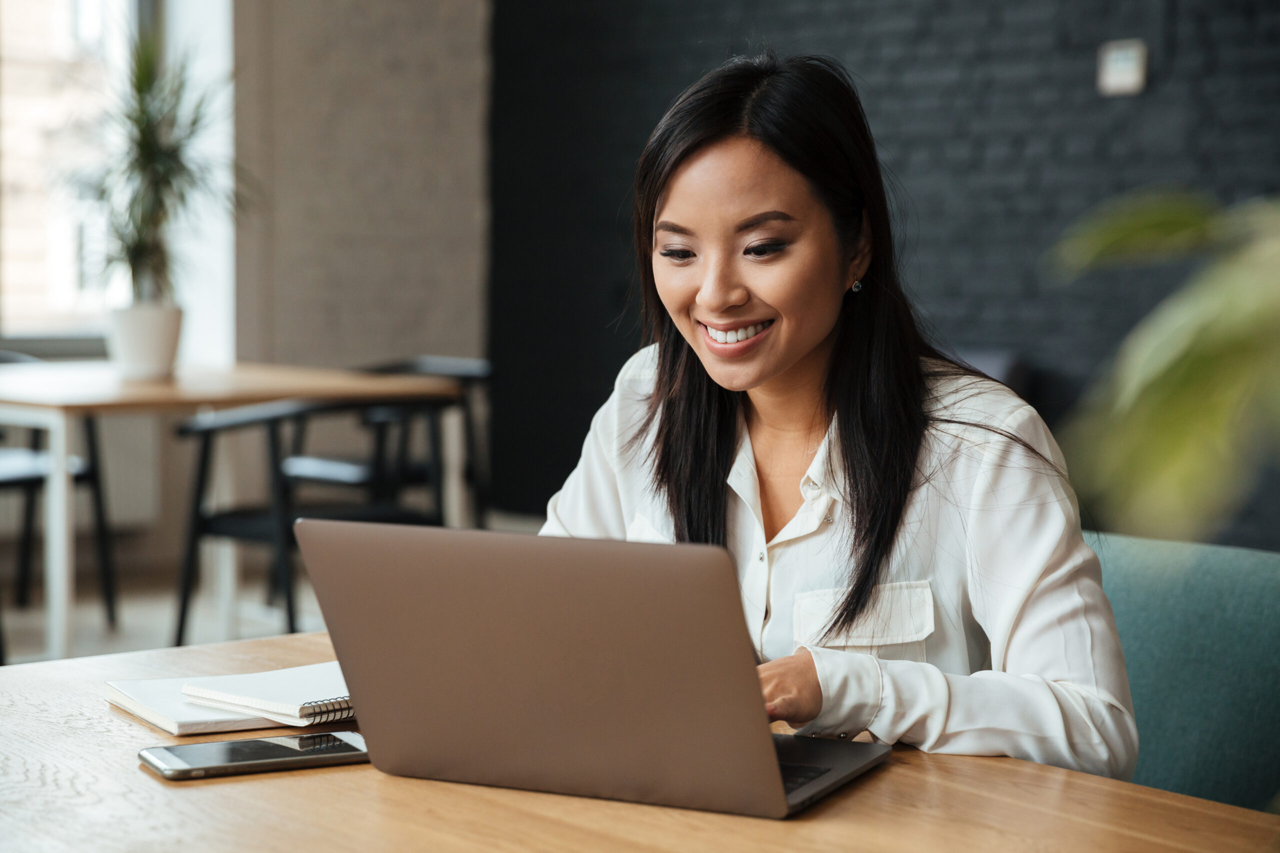 filipina working as a remote quality control analyst with a laptop in office