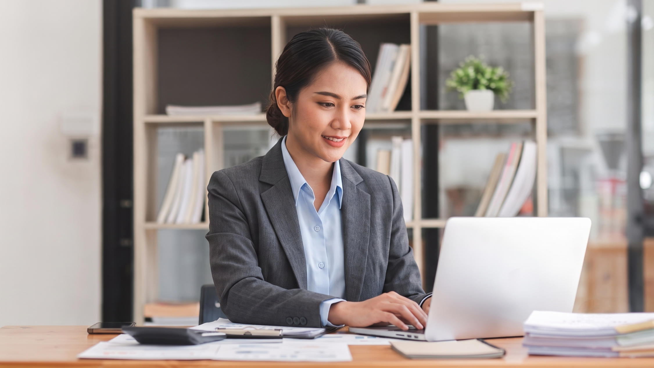 filipina remote financial accountant analyzing data in a laptop