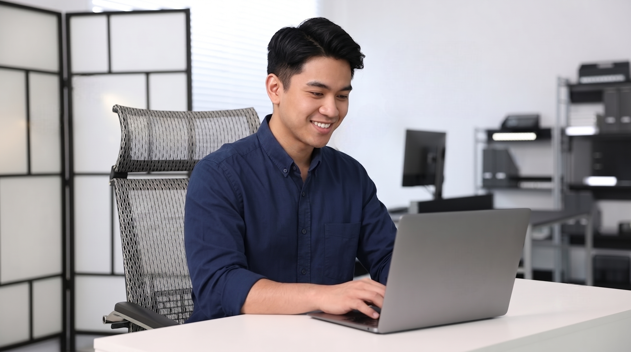 filipino remote integrations engineer analyzing workflow with a laptop in an it office