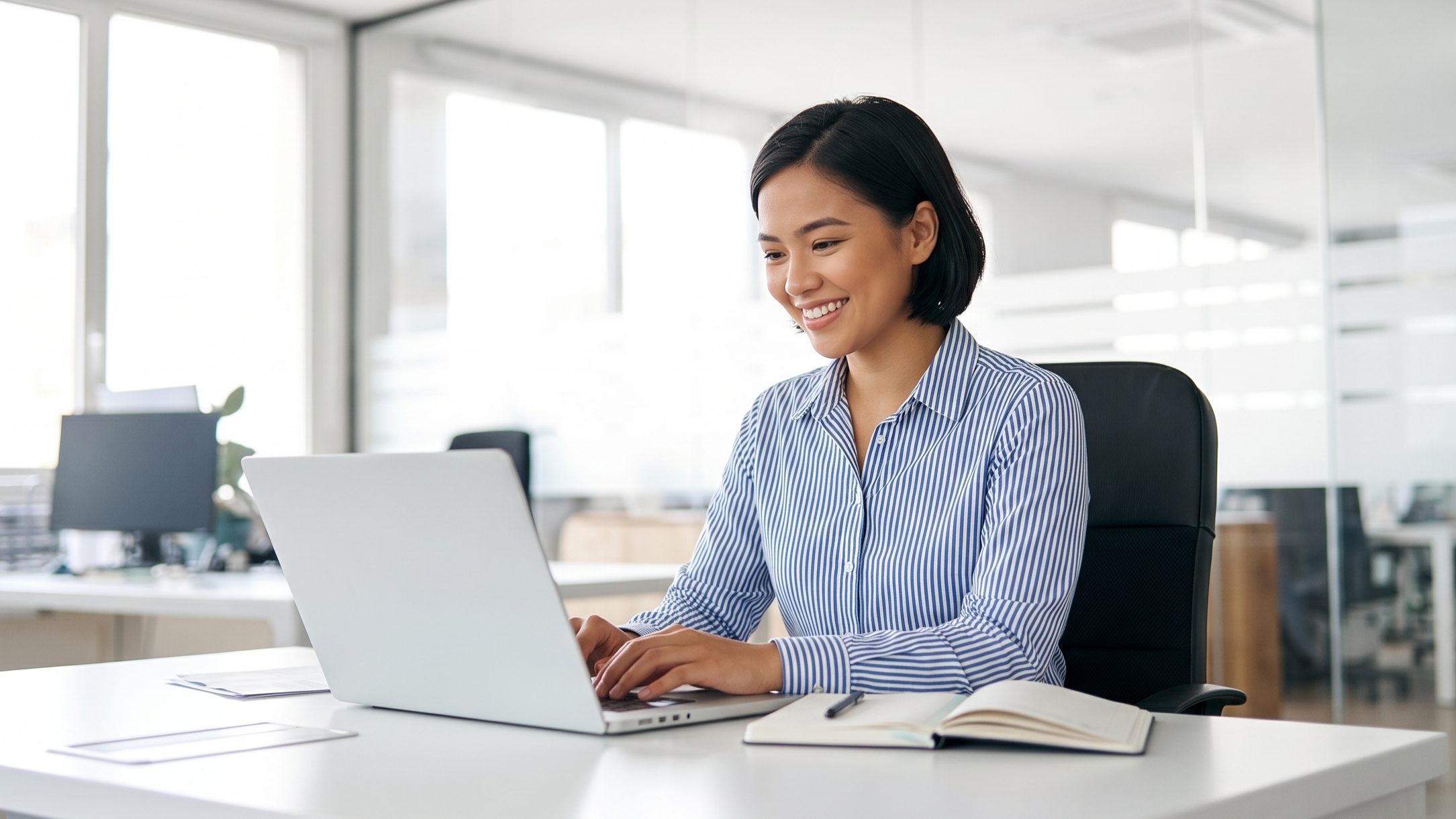 professional working on a laptop at a modern office desk for outsourced investment operations