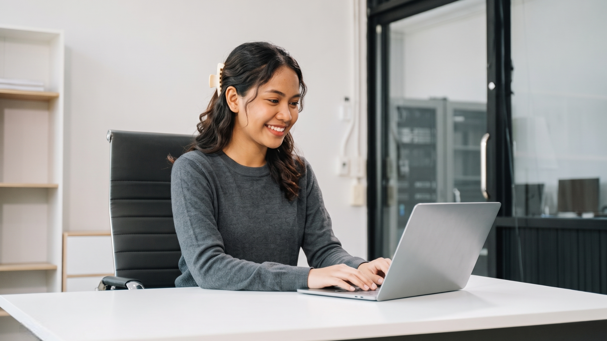 an order fulfillment coordinator works on a laptop in a modern remote office setting