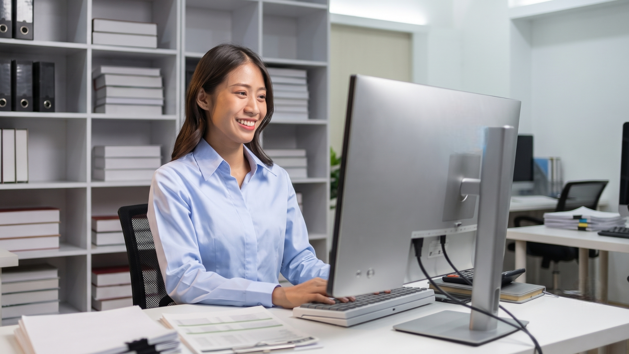 offshore bid specialist managing project documentation on a computer in a clean office setting