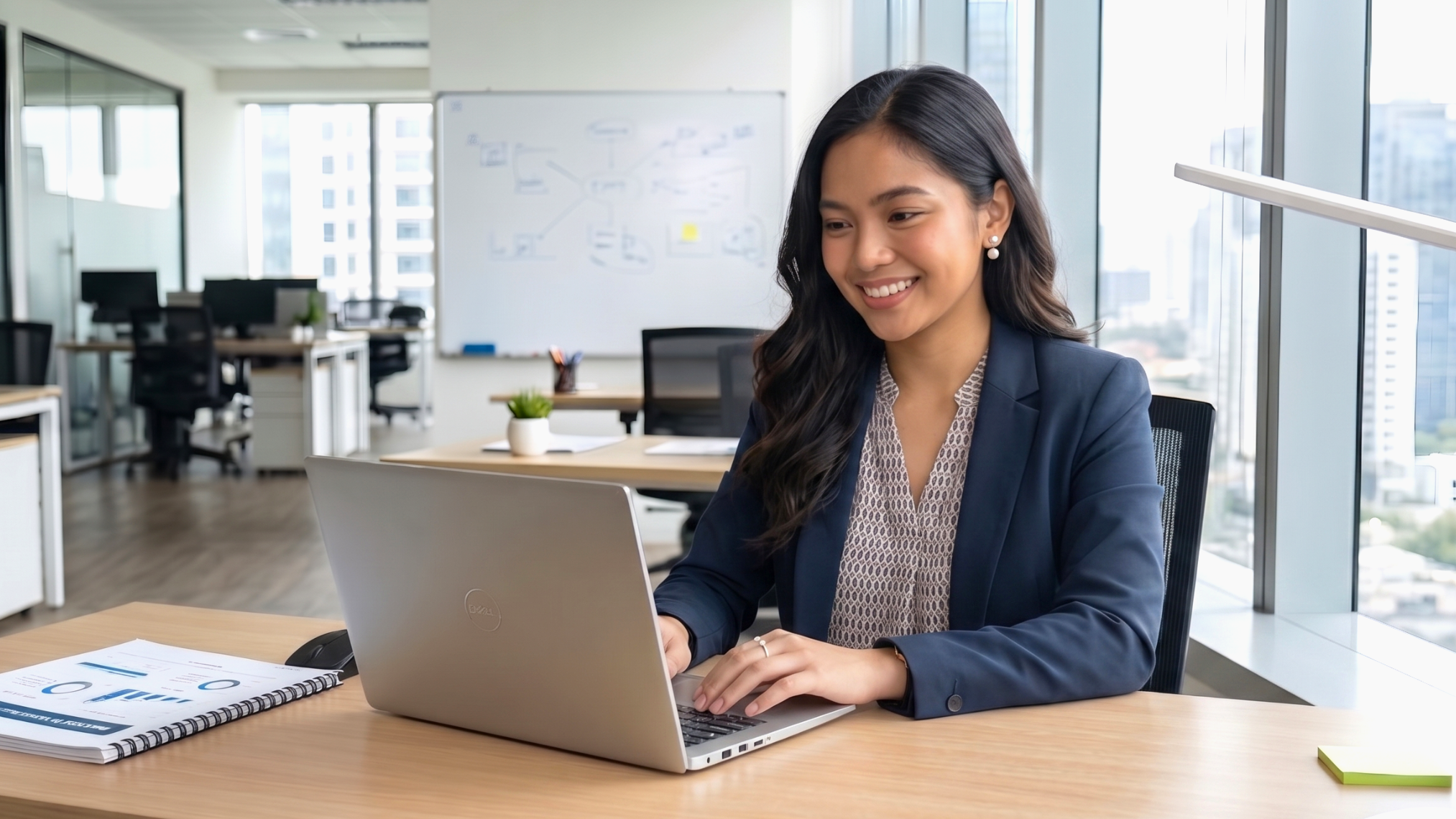 remote asset management coordinator working in a bright office with laptop on the table