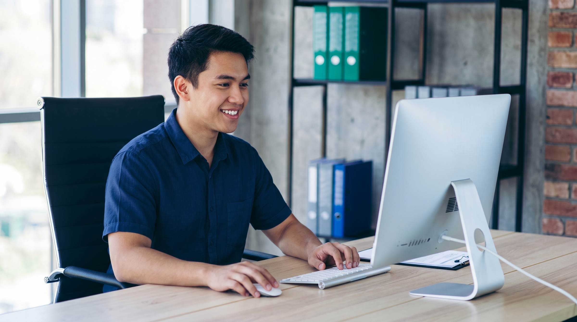 Filipino SAP SuccessFactors certified professional working on a computer in a modern office